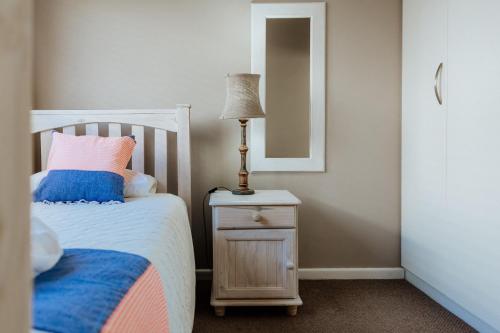 a bedroom with a bed and a lamp on a night stand at Roseveldt in Paternoster