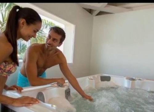 a man and a woman in a bath tub at **Magnifique Nouveau Bungalow** Village Siblu - Plage - Piscine - Sauna... in Valras-Plage