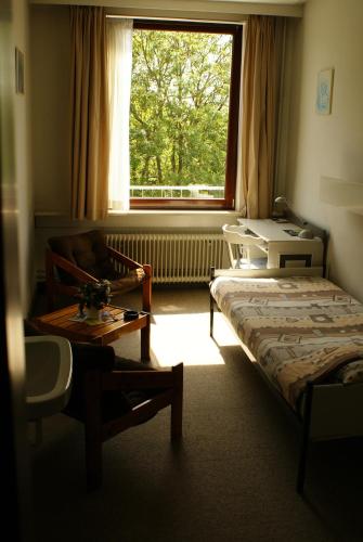 ein Zimmer mit einem Bett, einer Couch und einem Fenster in der Unterkunft Hotel Domstad in Utrecht