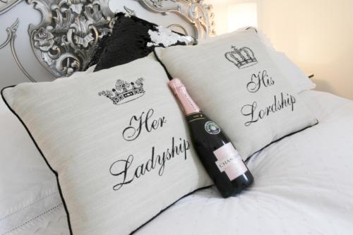 Una botella de champán sentada en una cama con almohadas en Ugthorpe Lodge Hotel en Whitby