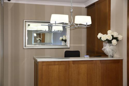 a reception desk with a mirror and a vase of flowers at Pod Lipą in Gorzów Śląski