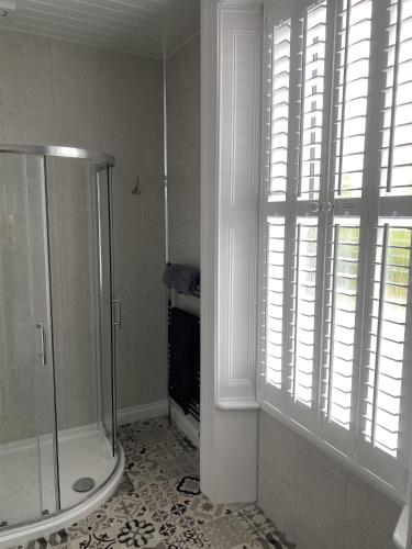 a white bathroom with a shower and a window at Ugthorpe Lodge Hotel in Whitby