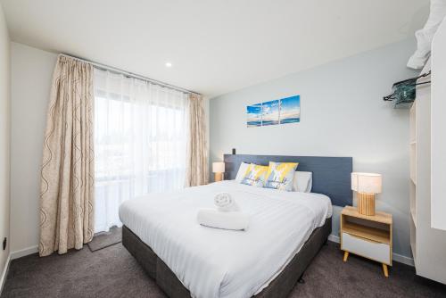a bedroom with a large white bed and a window at 37 Galaxy B in Lake Tekapo
