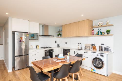 a kitchen with a wooden table and chairs in it at 37 Galaxy B in Lake Tekapo