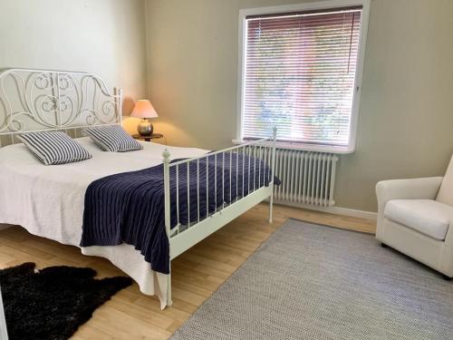 1 dormitorio con 1 cama, 1 silla y 1 ventana en Brunsbergs Herrgård appartement, en Brunskog