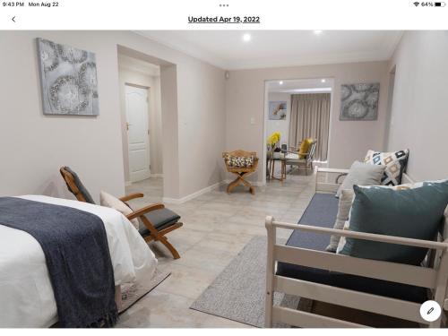 a bedroom with a bed and a living room at Rueby’s Apartment 101 in Dullstroom