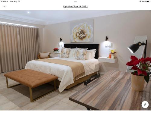 a bedroom with a large bed and a table at Rueby’s Apartment 101 in Dullstroom