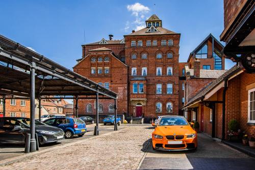 an orange car parked in front of a brick building at The Brewhouse, Castle Brewery, Newark in Newark-on-Trent