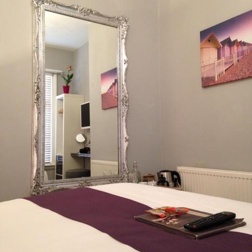 a bedroom with a bed and a mirror at Brighton Inn Boutique Guest Accommodation in Brighton & Hove