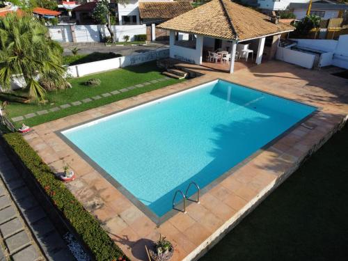 Casa Vilas do Atlântico, 3 quartos próximo a praia في لورو دي فريتاس: اطلالة علوية على مسبح ازرق كبير