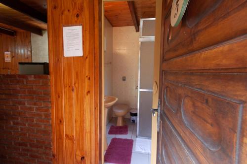 eine Tür, die in ein Bad mit WC führt in der Unterkunft Chalés Dona Zenta in Monte Verde