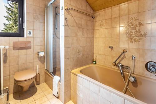 a bathroom with a tub and a toilet at Ferienwohnung Cherine in Gailingen