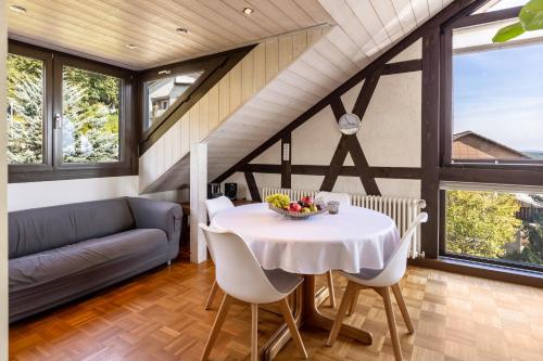 a dining room with a table and a couch at Ferienwohnung Cherine in Gailingen