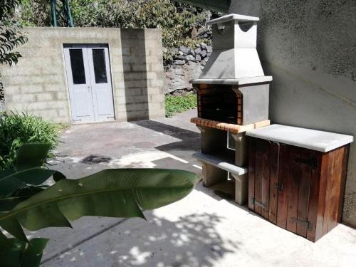 a outdoor stove with a door in a yard at Calheta Lofts ii in Calheta