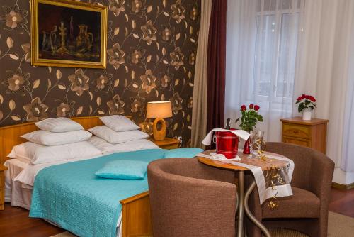 a bedroom with a bed and a table with a chair at Apartament Kamienica in Płock