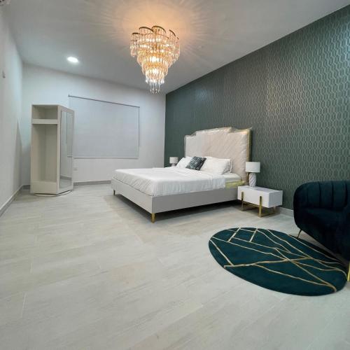 - une chambre avec un lit et un lustre dans l'établissement Dhakira Resort, à Adh Dhakhīrah