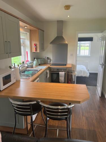a kitchen with a wooden table and two chairs at Smythe Cottage in Kirkistown