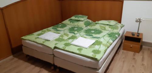 トカイにあるBorgalériaのベッドルーム1室(ベッド1台、緑の掛け布団付)