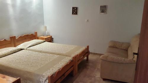 ein Schlafzimmer mit einem Bett und einem Stuhl in der Unterkunft Danaides Bungalows in Tolo