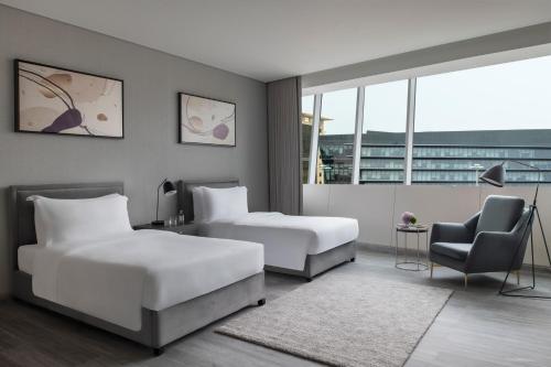 una camera d'albergo con due letti e una sedia di Steigenberger Residence Doha a Doha