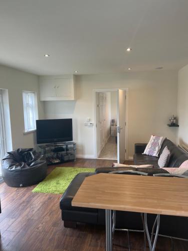 a living room with a couch and a flat screen tv at Smythe Cottage in Kirkistown