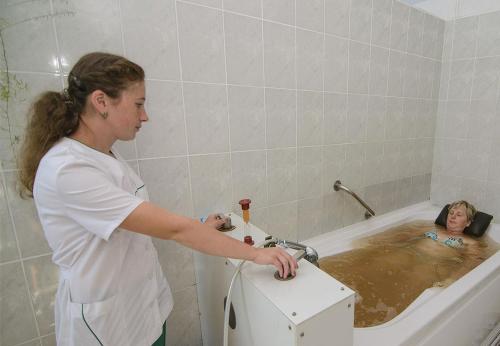 a woman in a bath tub holding a doll at Girska Tysa Health Resort in Kvasy