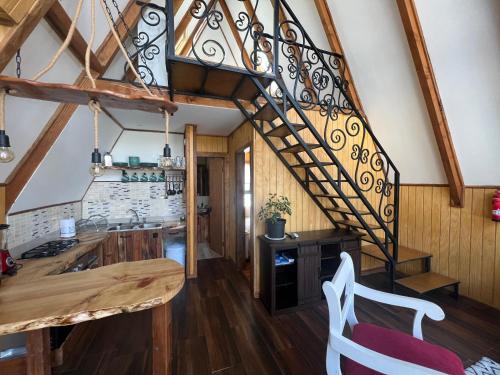 a kitchen with a spiral staircase in a house at CABAÑAS BOSQUE NEVADO in Malalcahuello