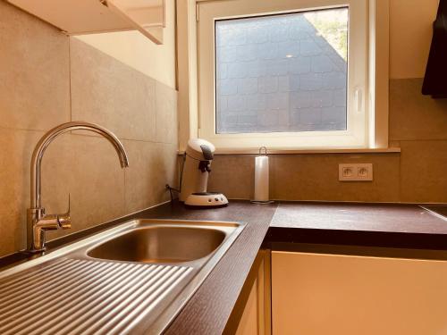 eine Küche mit einem Waschbecken und einem Fenster in der Unterkunft Casa Monica in Malmedy