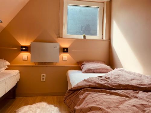 2 Betten in einem kleinen Zimmer mit Fenster in der Unterkunft Casa Monica in Malmedy