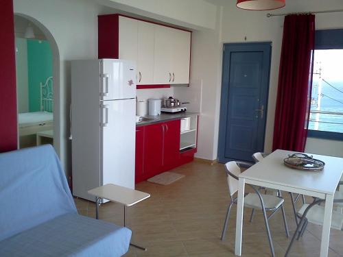 eine Küche mit einem weißen Kühlschrank und einem Tisch mit Stühlen in der Unterkunft Dimitris House in Karystos