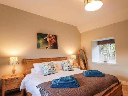 a bedroom with a bed with two blue towels on it at Bonnach in Muir of Ord