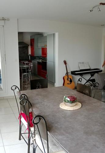 een keuken met een tafel met een hoed erop bij Chambre #1 dans appartement partagé - Proche des Vosges in Thann