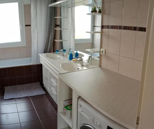 une salle de bain blanche avec un lavabo et un miroir dans l'établissement Chambre #1 dans appartement partagé - Proche des Vosges, à Thann