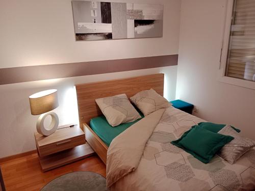 een slaapkamer met een bed met een houten hoofdeinde bij Chambre #1 dans appartement partagé - Proche des Vosges in Thann