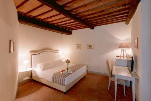 a hotel room with a bed, table and a lamp at Borgo Sant'Ambrogio - Resort in Pienza