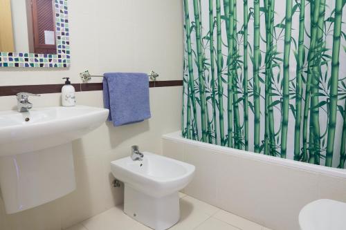 a bathroom with a sink and a toilet and a shower curtain at Alojamiento Particular in Almería