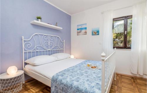 Beautiful Home In Prizna With Wifi في بريزنا: غرفة نوم صغيرة بها سرير أبيض ونافذة