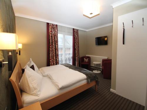 a hotel room with a bed and a window at Gasthof Weissenbach in Strobl