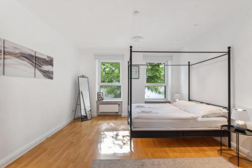 een slaapkamer met een hemelbed en witte muren bij Bright 3-room apartment near Prenzlauer Berg in Berlijn