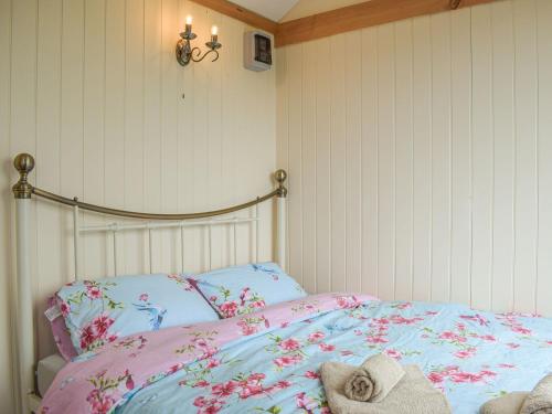 a bedroom with a bed with pink and blue sheets at The Sawyers Hut-uk39775 in Trefeglwys
