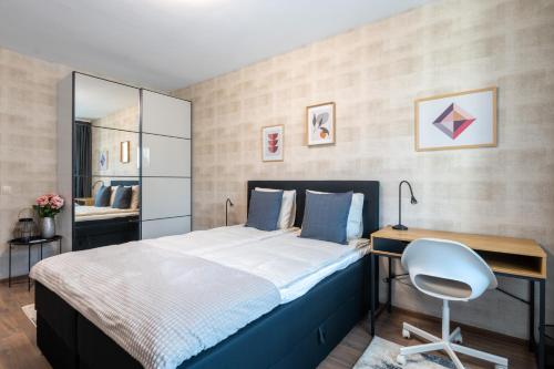 a bedroom with a bed and a desk and a chair at New Stylish 1-bedroom Flat in Business District in Sofia
