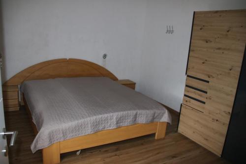 - une chambre avec un lit et une commode en bois dans l'établissement Ferienhaus Blaukovitsch, à Weiz