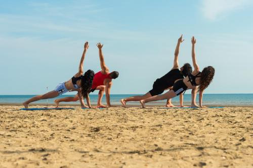 a group of people doing yoga on the beach at Isola di Albarella in Isola Albarella