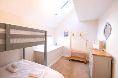 - une chambre avec des lits superposés et une baignoire dans l'établissement Old School Mews By The Sea Broadstairs, à Broadstairs