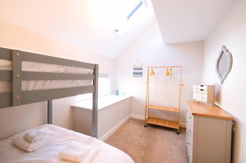 a bedroom with a bunk bed and a bath tub at Old School Mews By The Sea Broadstairs in Broadstairs