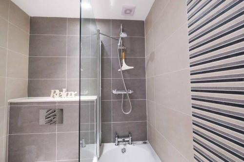 a bathroom with a shower and a bath tub at Old School Mews By The Sea Broadstairs in Broadstairs