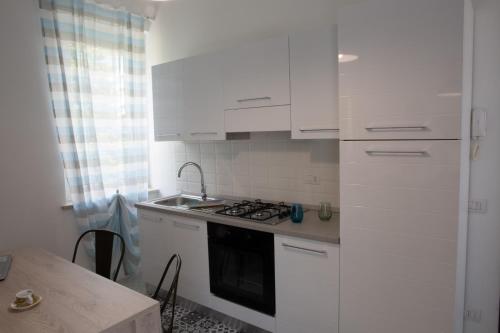 a kitchen with white cabinets and a sink and a stove at Mercante In Fiera in Verona