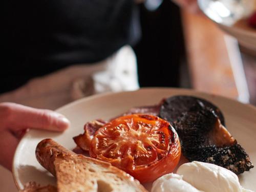 Horsley Lodge في ديربي: طبق من الطعام مع الطماطم والخبز المحمص