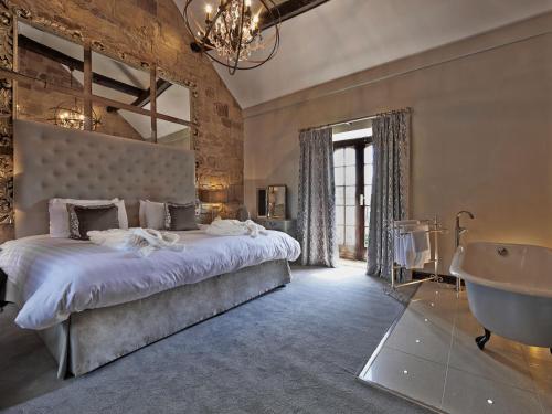 a bedroom with a bed and a tub and a sink at Horsley Lodge in Derby