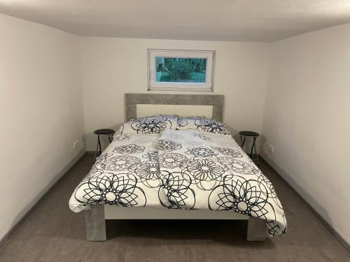 a bedroom with a bed with a black and white comforter at Bungalow Lange in Schwielochsee